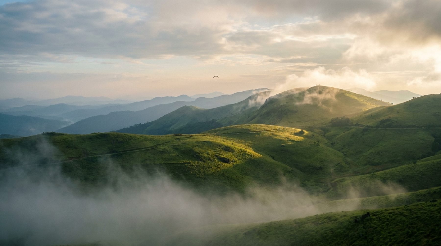 Mist lifting over the rolling meadows of Vagamon, Kerala — the hill station's weather changes rapidly through the year