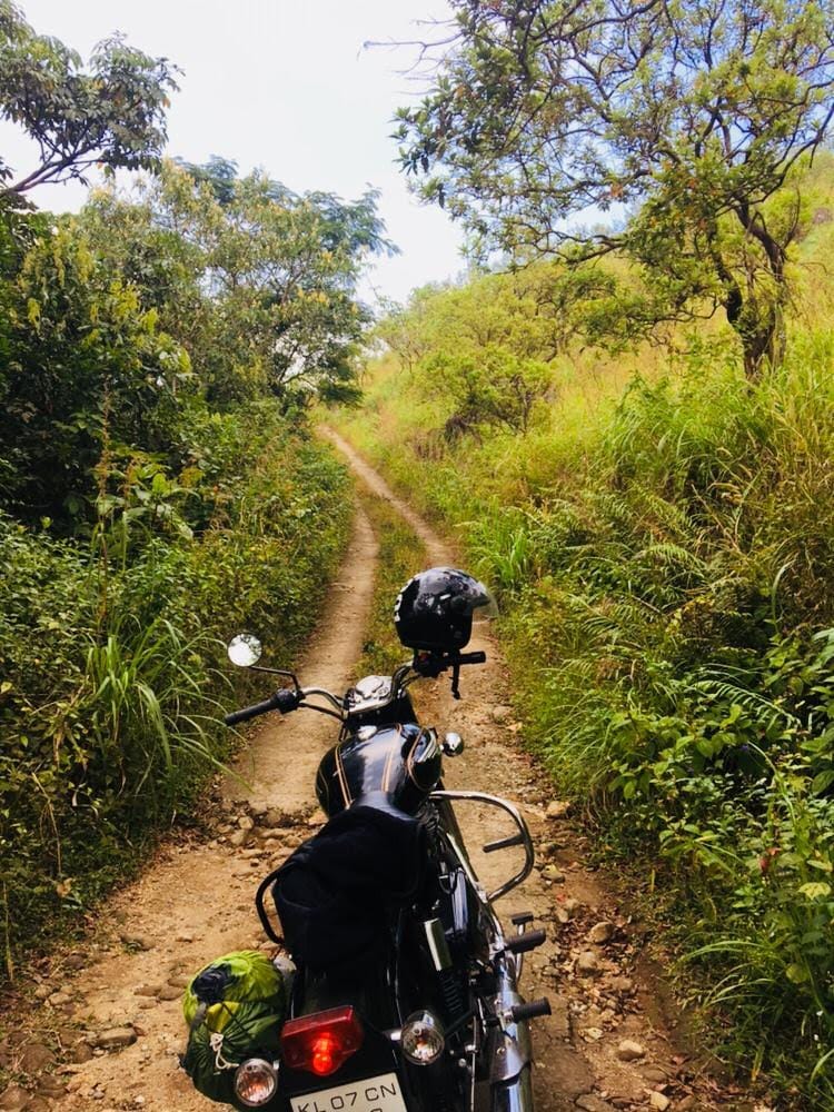 A motorbike parked on an off-road forest trail near Yendayar, Kerala